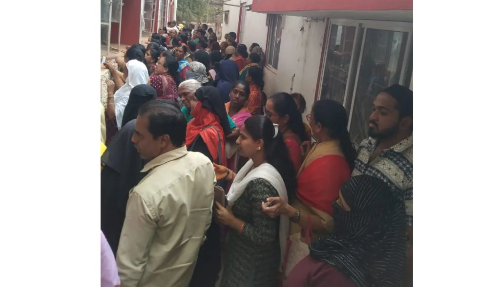 Beneficiaries line up at post office for 'Grilahakshmi'