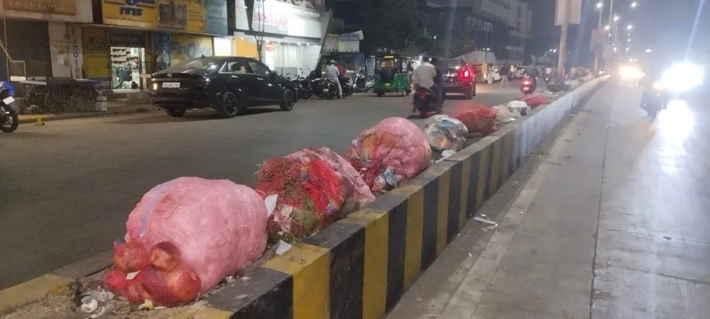 The bus stop divider looks like a garbage can