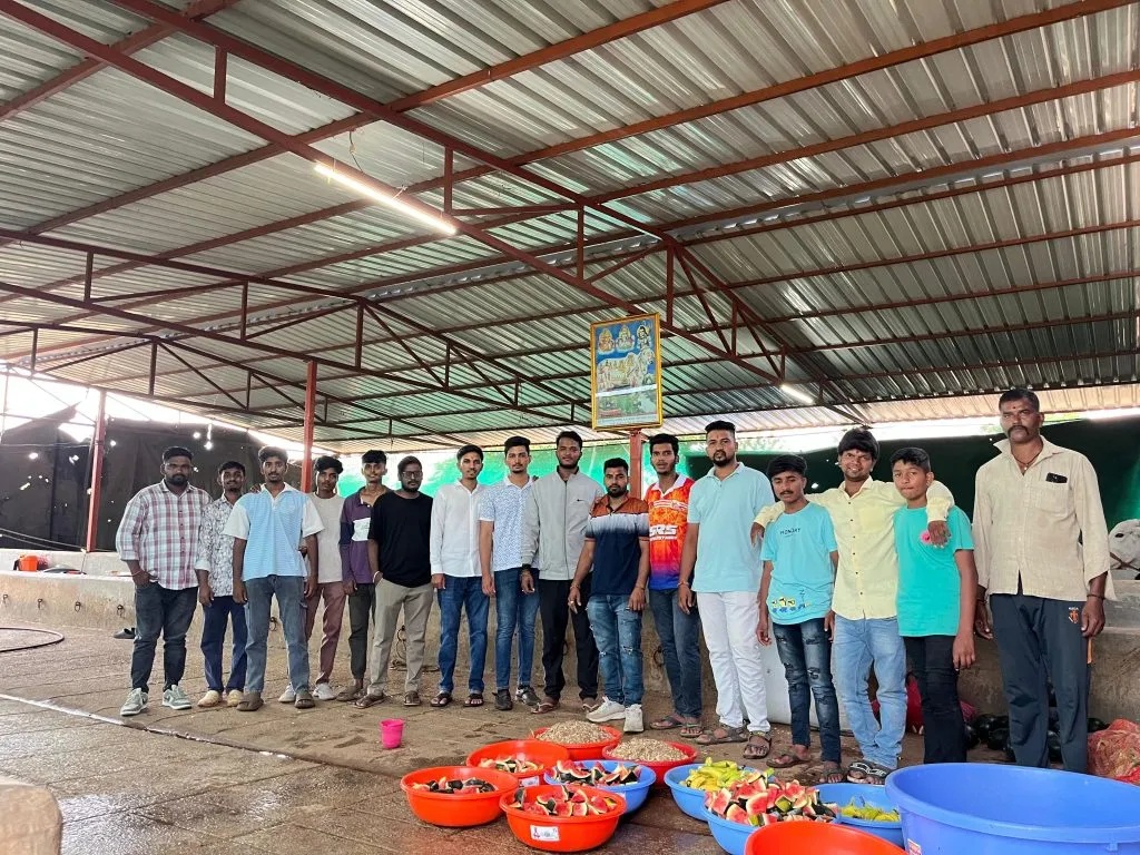 Youth distributes animal feed to cowshed