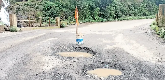 A flag planted in the potholes of Ambenali Ghat